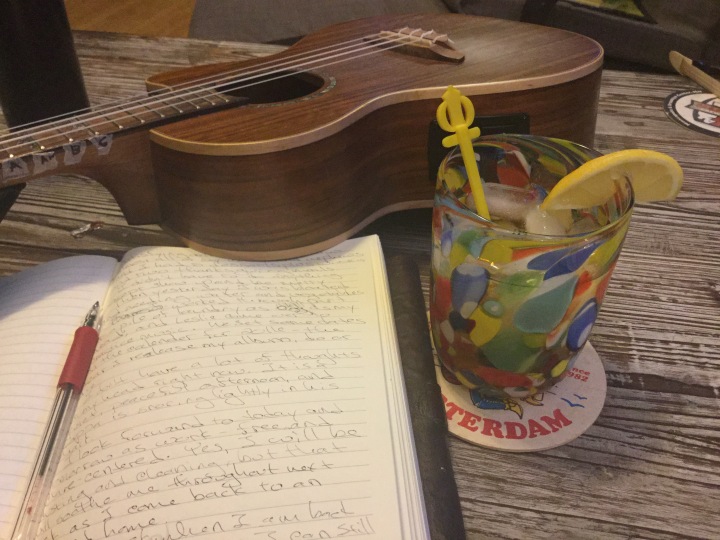 journal, ukulele and mixed drink